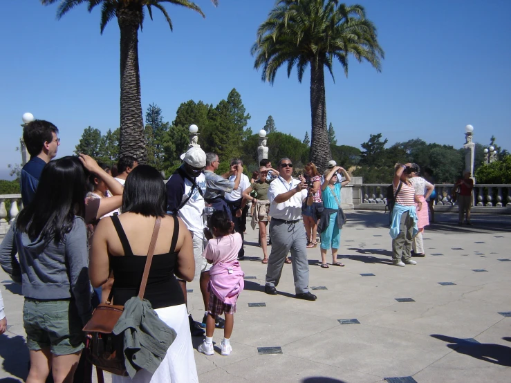 the group of people are standing in the park