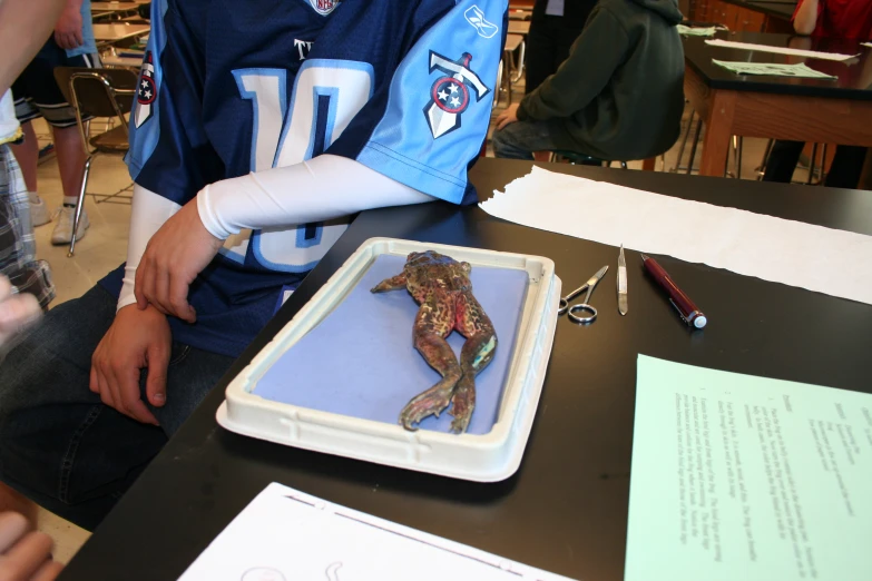 a boy who is wearing a uniform and sitting at a table