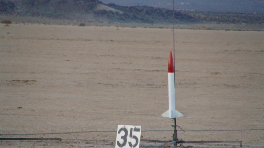 a large rocket with a sign on the fence