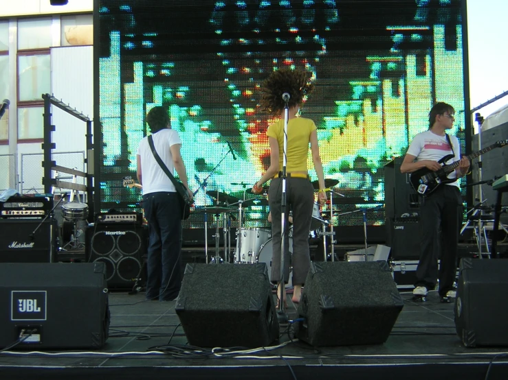 three men standing on stage next to each other