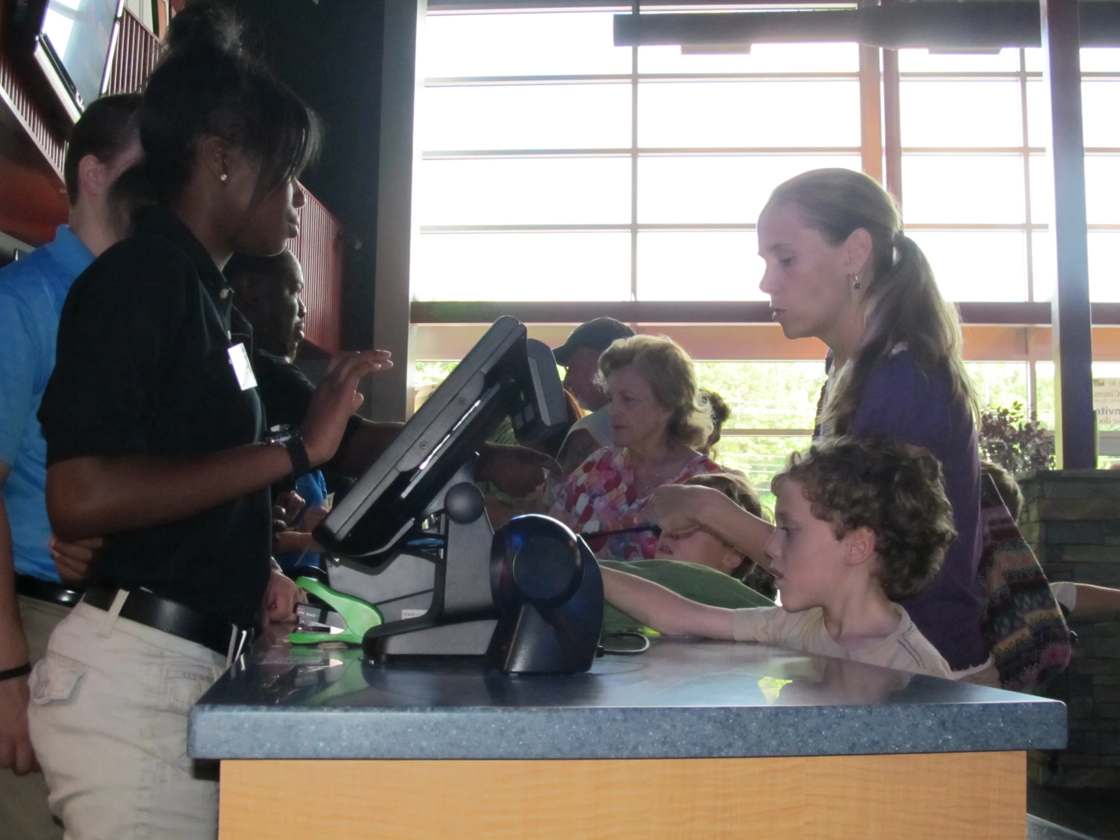 several people gathered together at the counter of a cafe