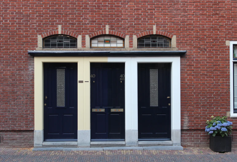 two doors are painted black in front of a building