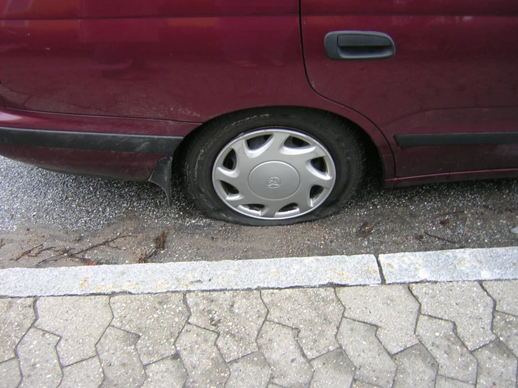 close up of a maroon car parked in the street