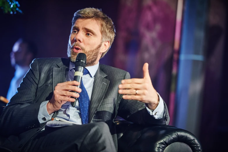 a person sitting on a chair with a microphone