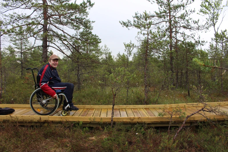 a person riding on a wheelchair in the woods