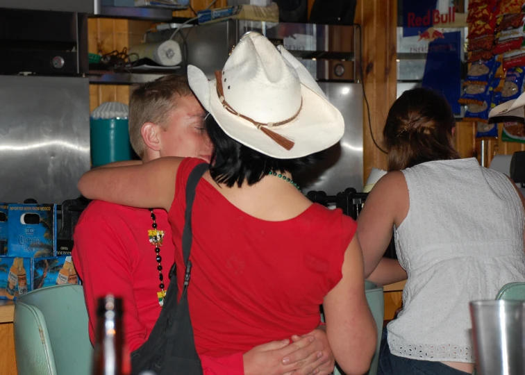 a couple kiss while standing in the kitchen