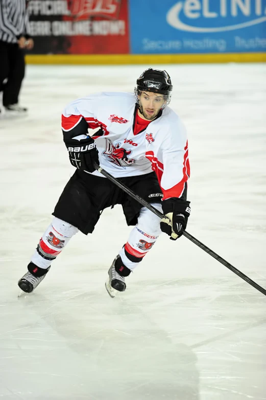 hockey player playing on ice with stick and black pants