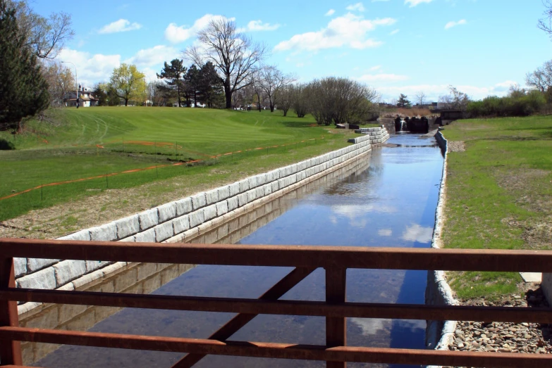 there is a long waterway that runs alongside a green area