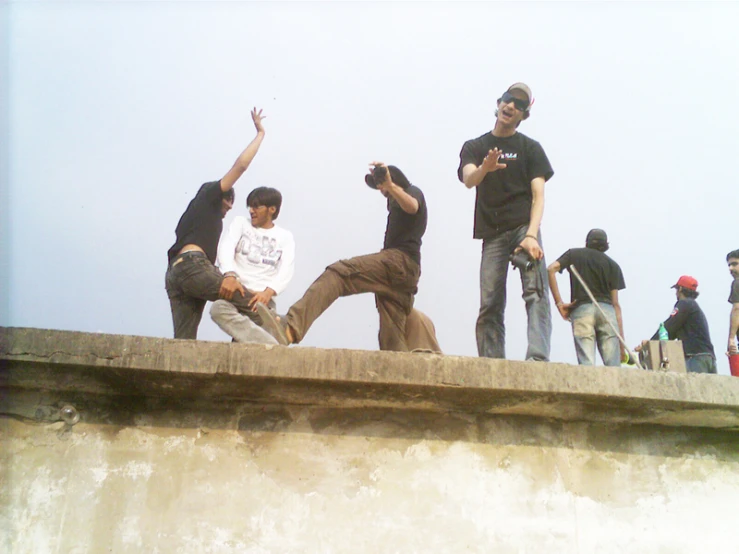 a group of young people standing on the edge of a wall