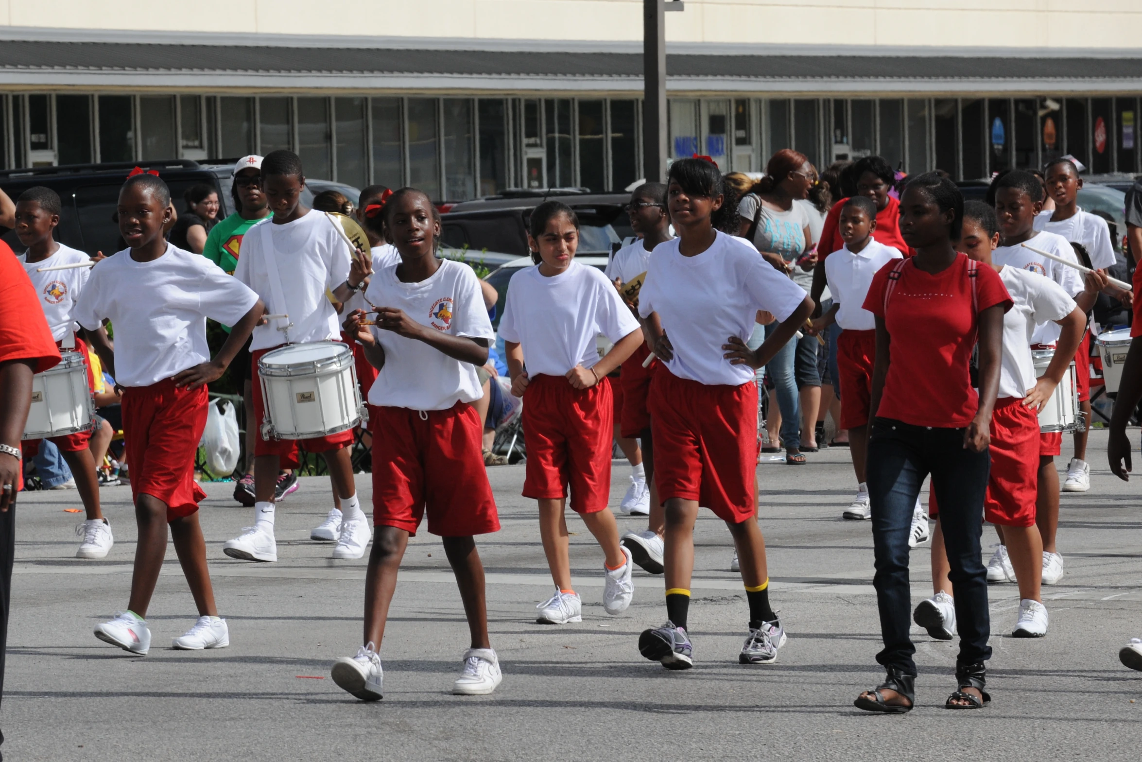 many people with marching instruments walk along the street