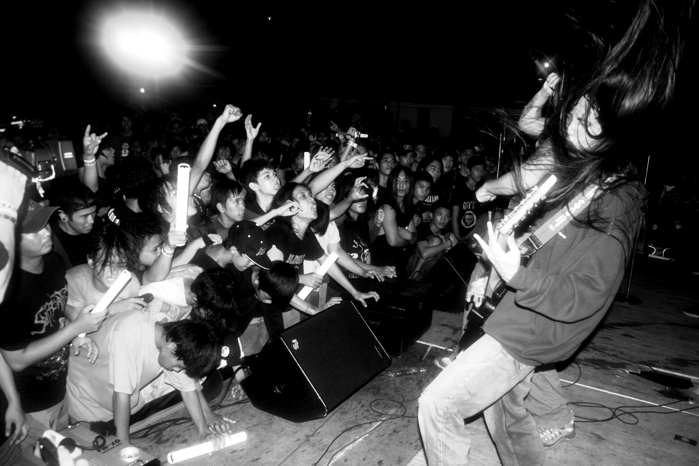 a black and white po of people holding up guitar sticks