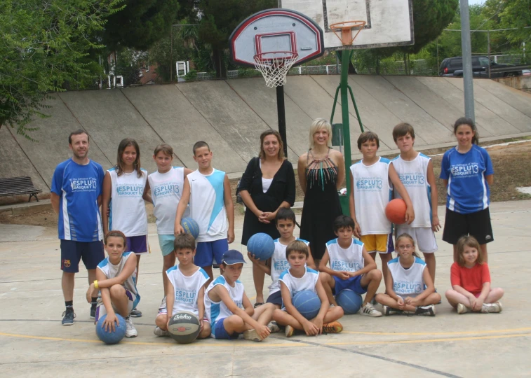 a group of children with adults on a court