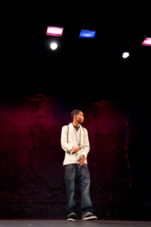 man walking on stage in white jacket and black shoes