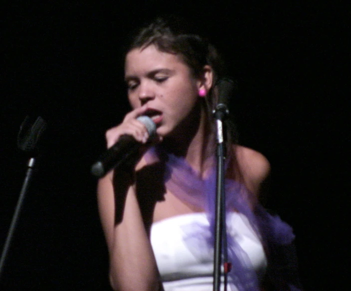 the woman is standing in front of a microphone