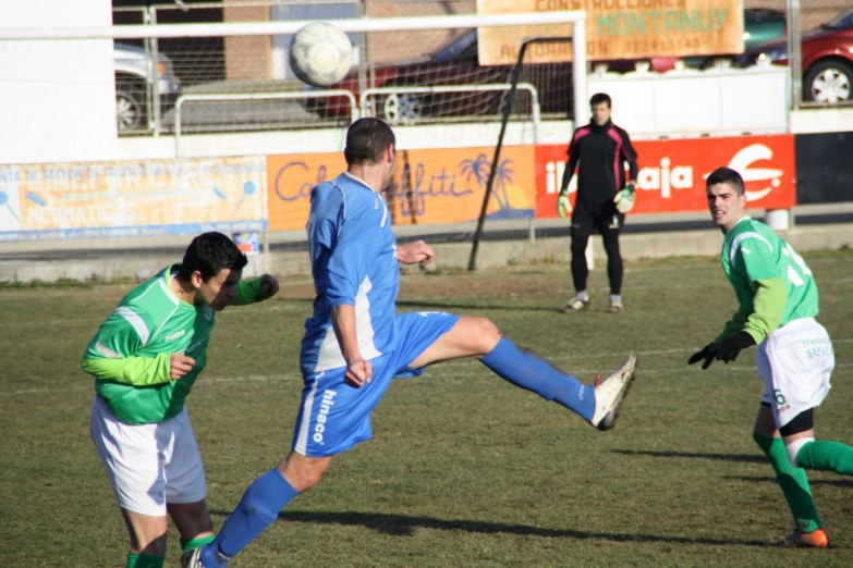 three soccer players are playing on a soccer field