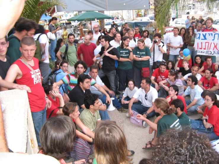 people crowd in an open area near a large crowd