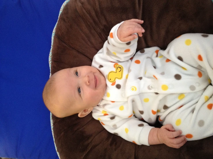 a baby sitting on a brown and brown bean bag chair