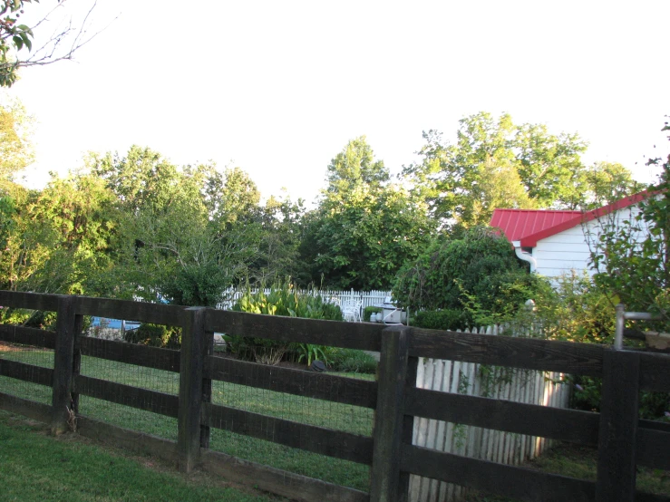 a brown wooden fence surrounded by lush green grass