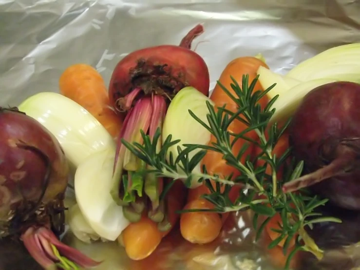 an assortment of vegetables laying on foil and ready to be eaten