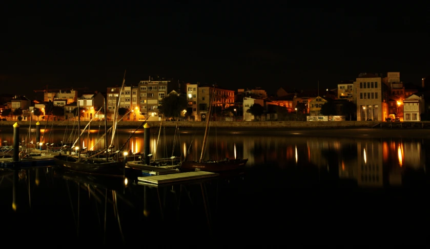 some sailboats sitting on water near a city