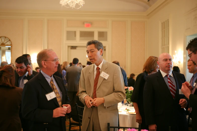 men in suits and ties standing in a large room