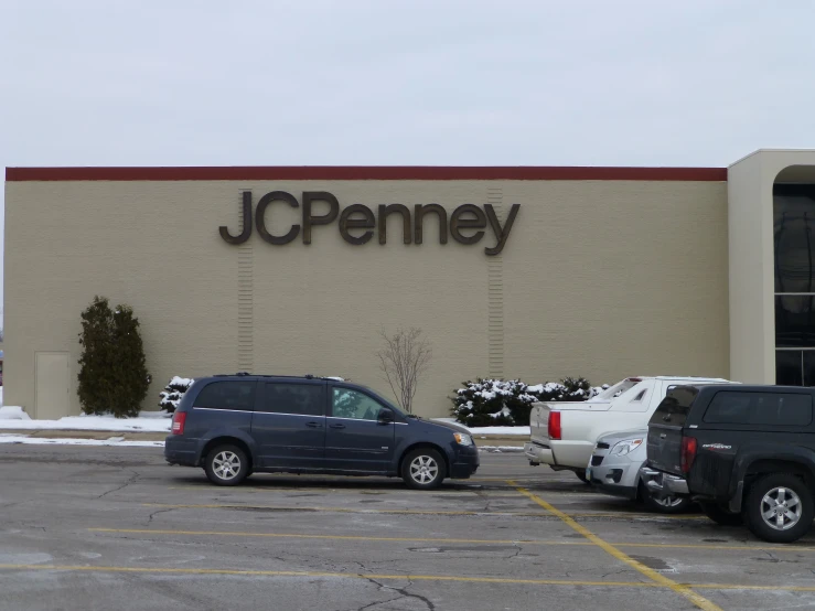 a jc penney building with cars parked in front of it