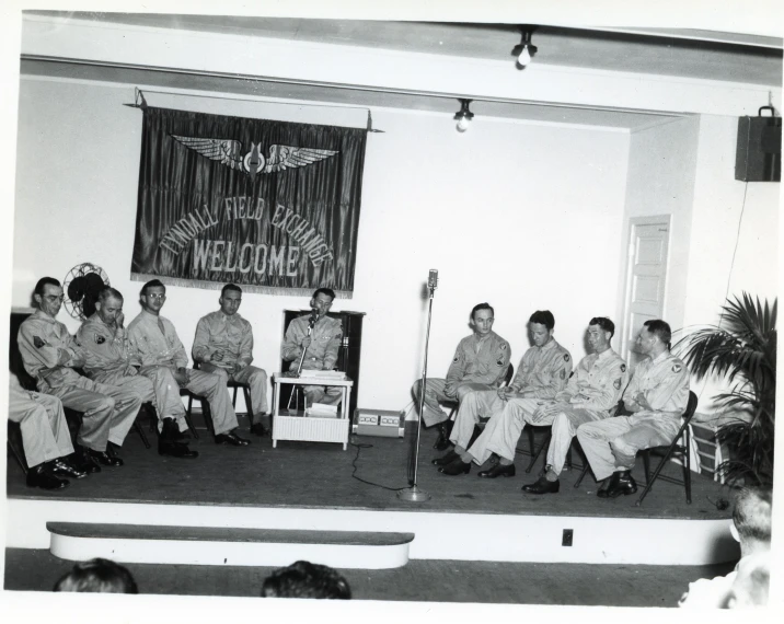 five people in colorful suits sit in front of an audience