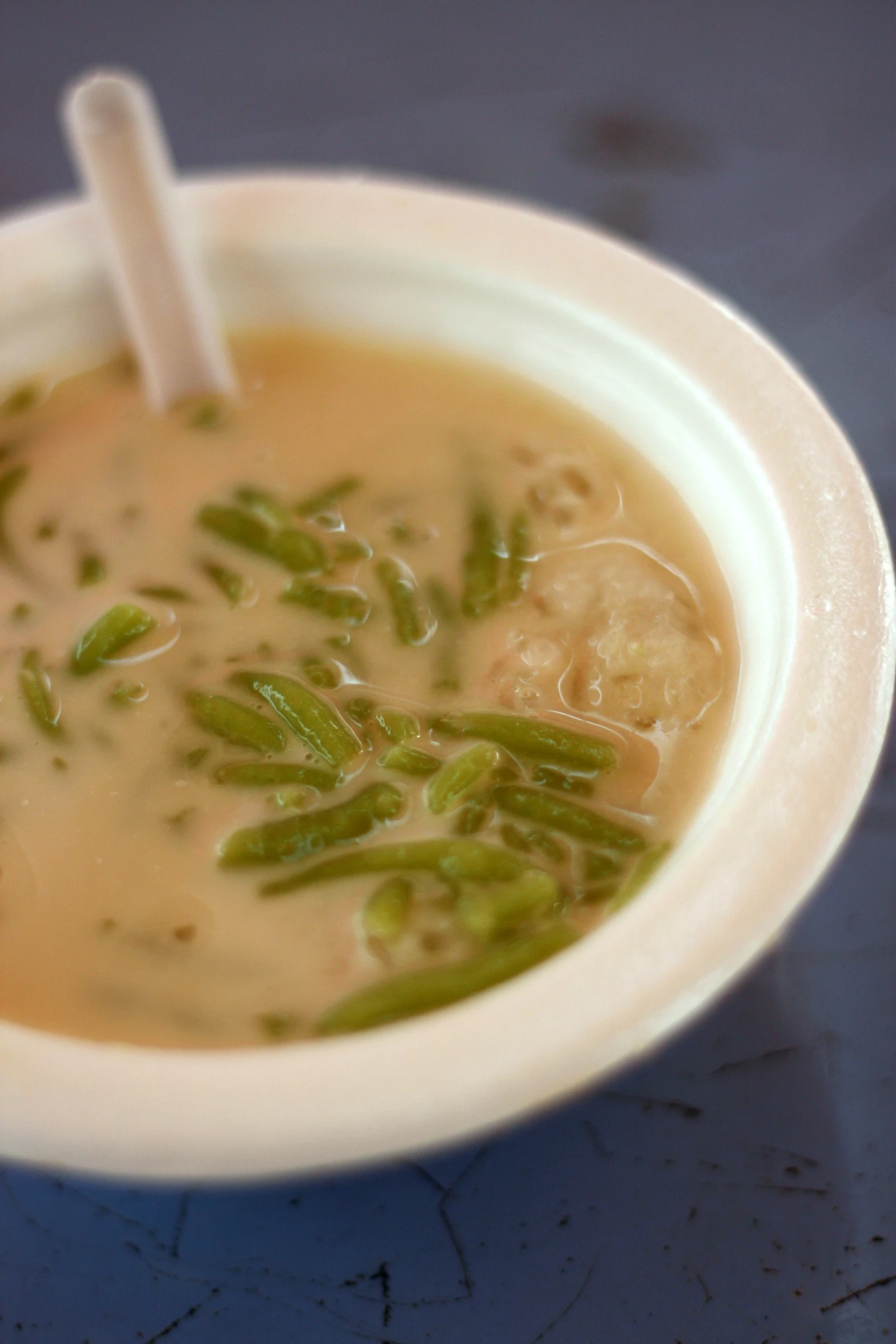 a white bowl containing soup on top of a table