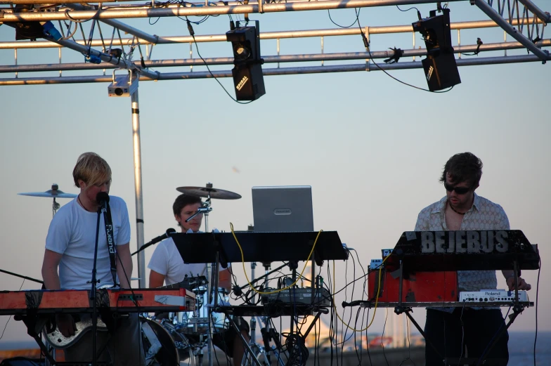 two people are playing instruments in front of two microphones