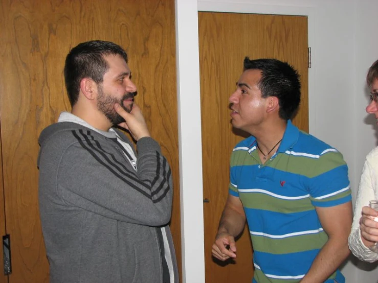 a man in blue shirt talking to another man