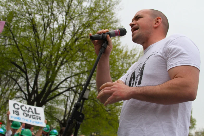 a man in white shirt singing at a microphone