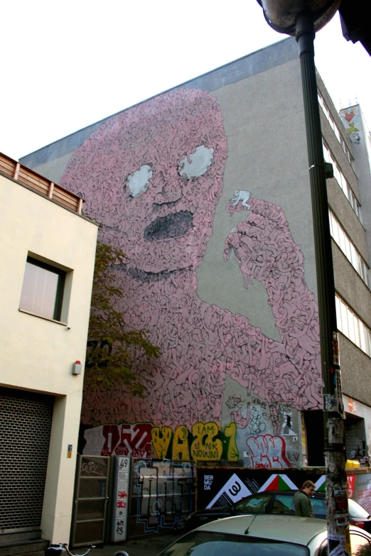 large mural by street artist on the side of building