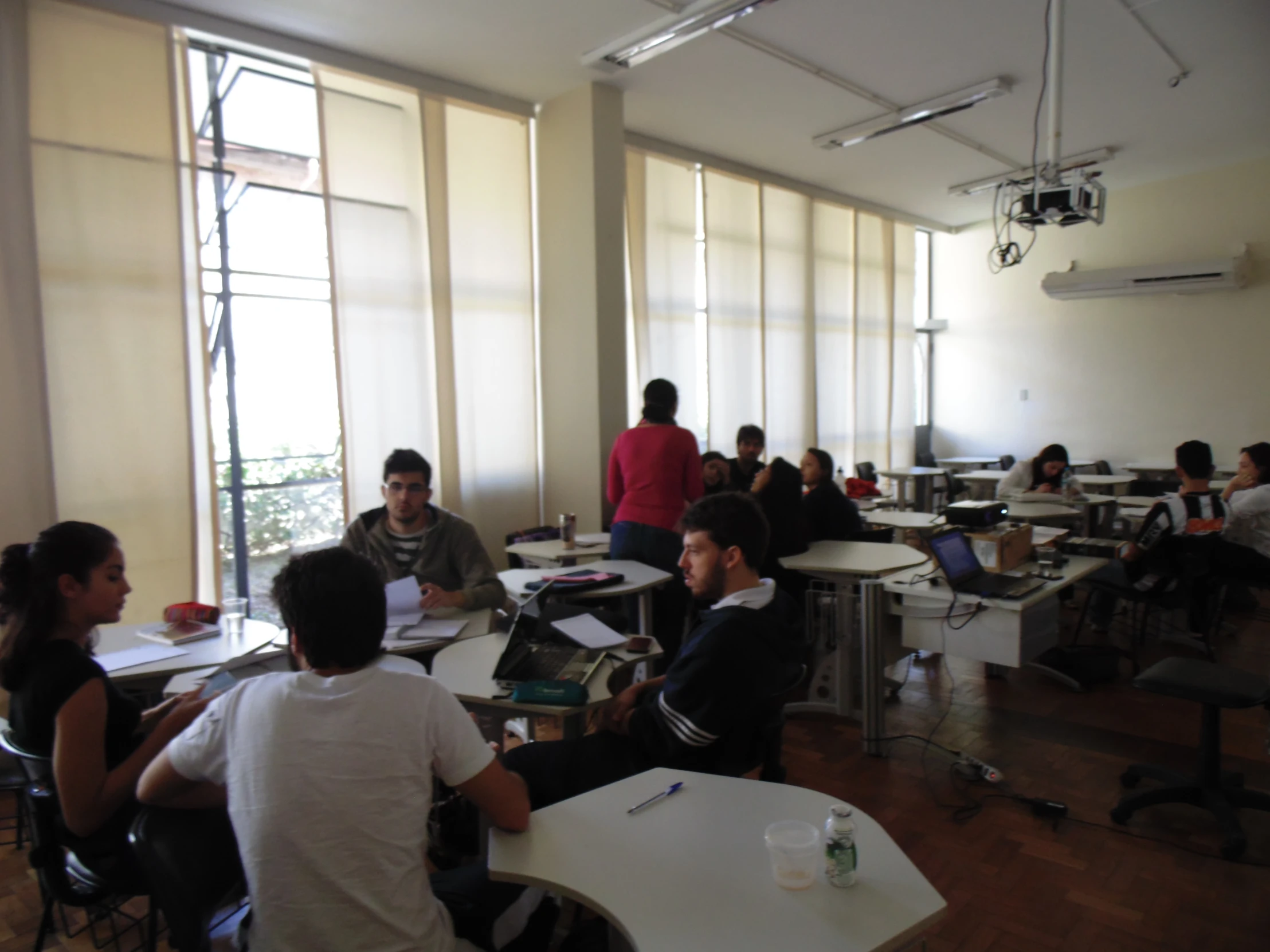 several people sitting at tables with laptops