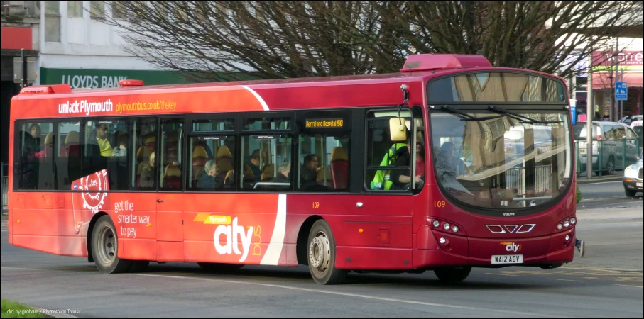 a red public transit bus on a city street