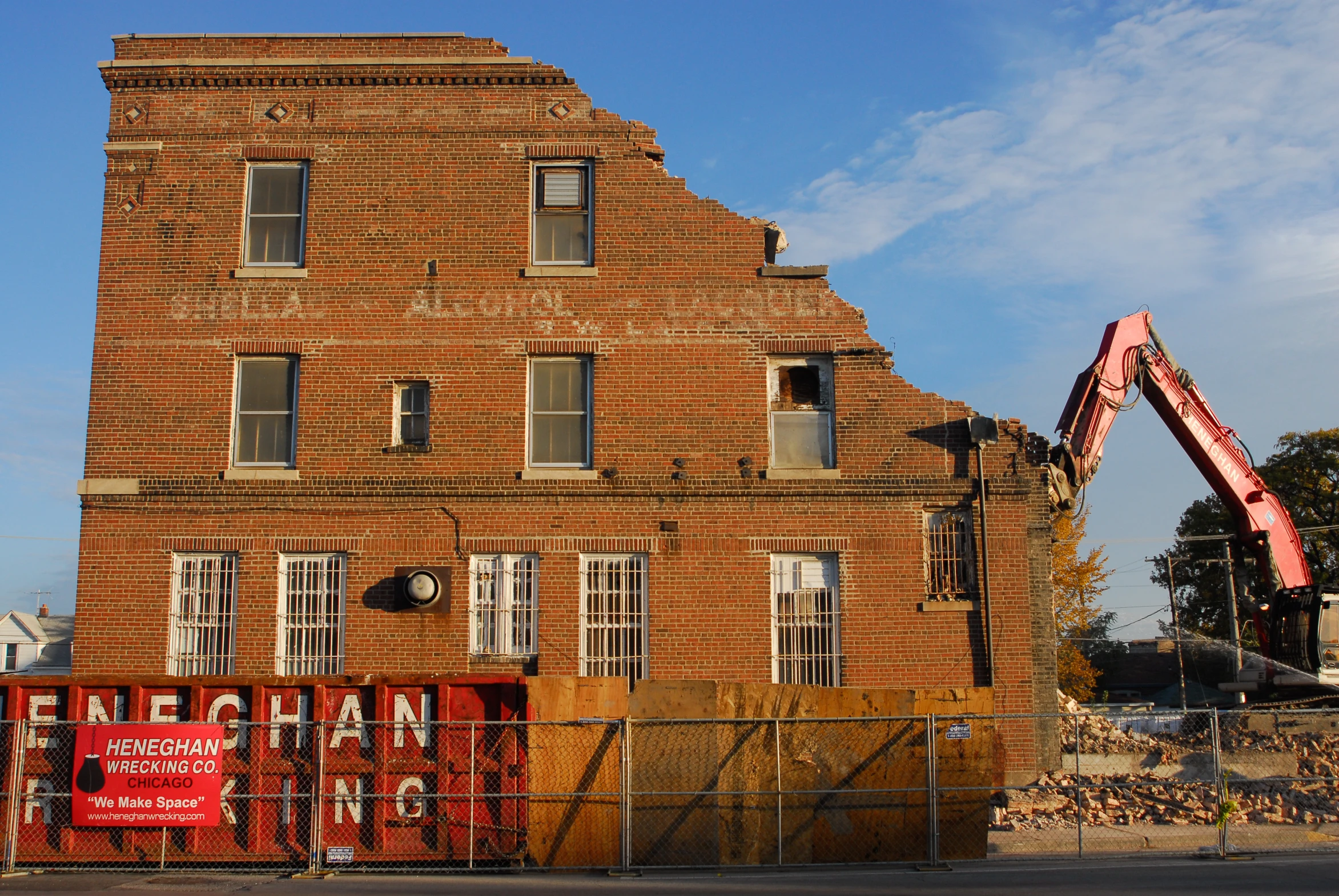 a large brick building in front of a crane