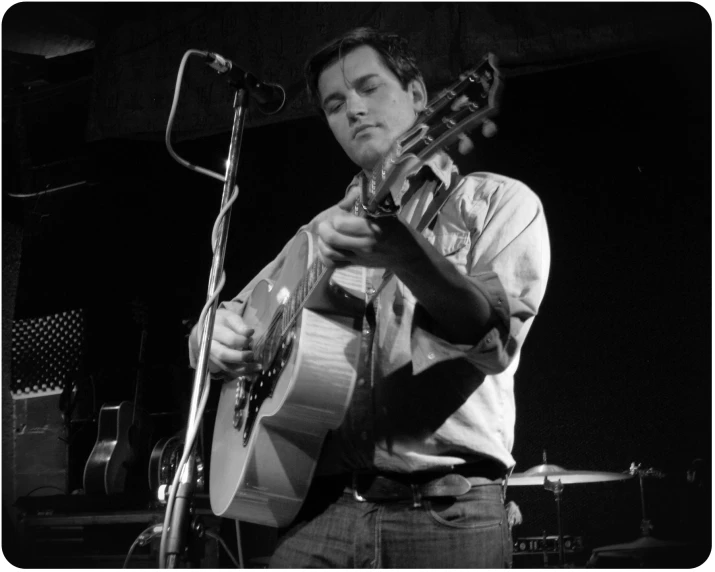 a person playing guitar at a microphone