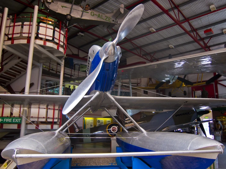 an old plane sits in the building in front of a red and white sign