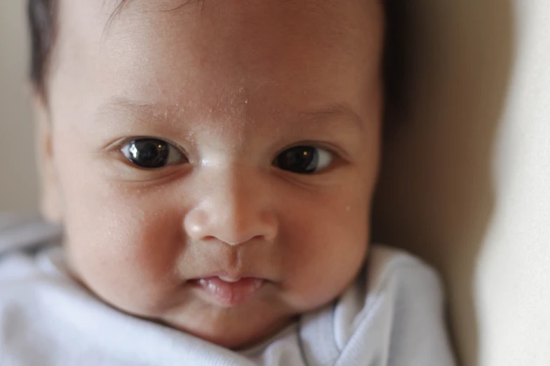 baby with very big eyes looks at the camera