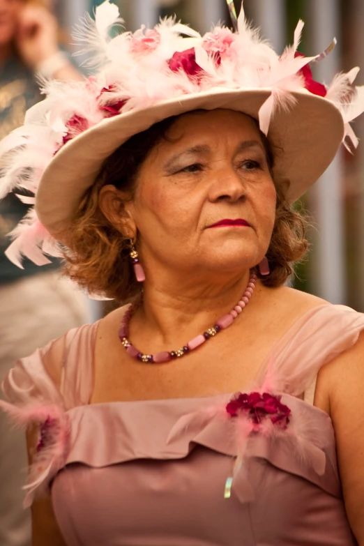 a woman wearing a pink hat with pink feathers