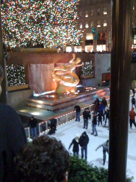 people are walking around a mall as christmas lights shine on the walls