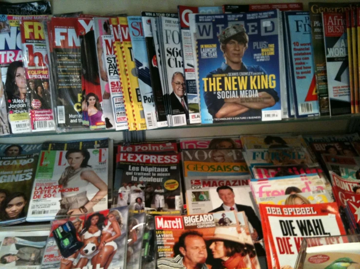 a bookcase full of magazines with covers on them