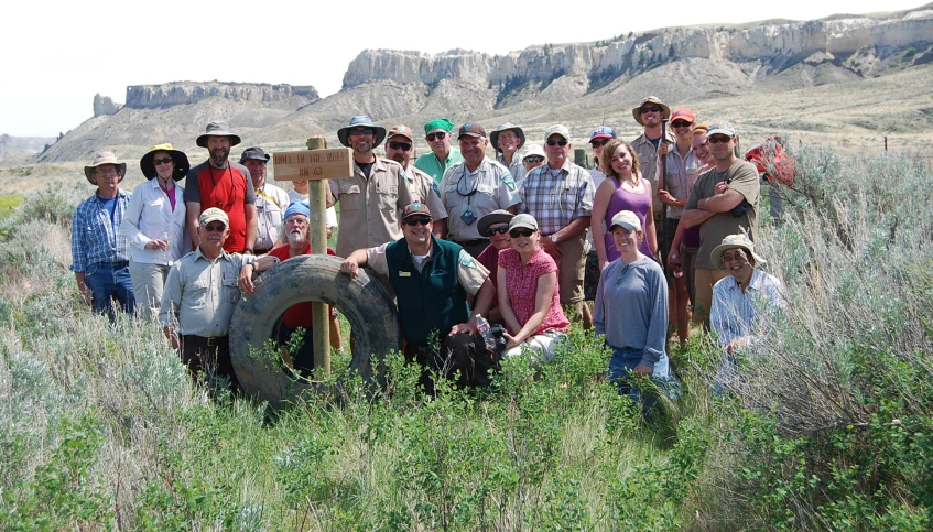 people are posing in front of a giant tire