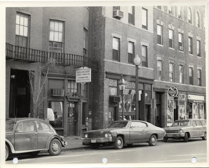 vintage car parked on the street in front of a brick building