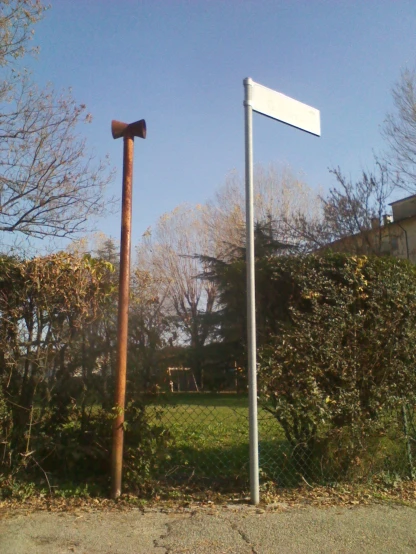 a street light and sign post near some trees