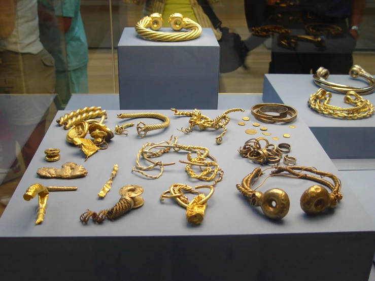 several different kinds of jewelry on display in a glass case