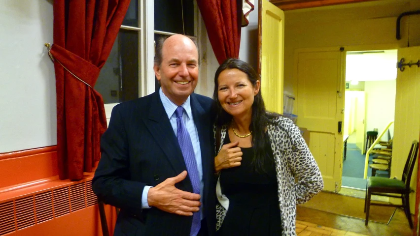 an older man and woman smiling next to a doorway