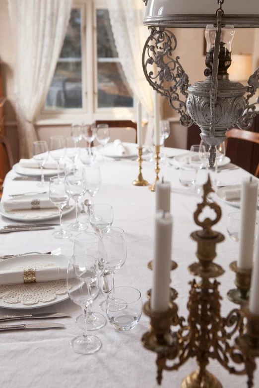 a dining table with some lit candles at it