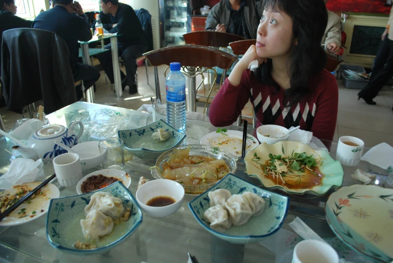 there is a woman sitting at a table full of food