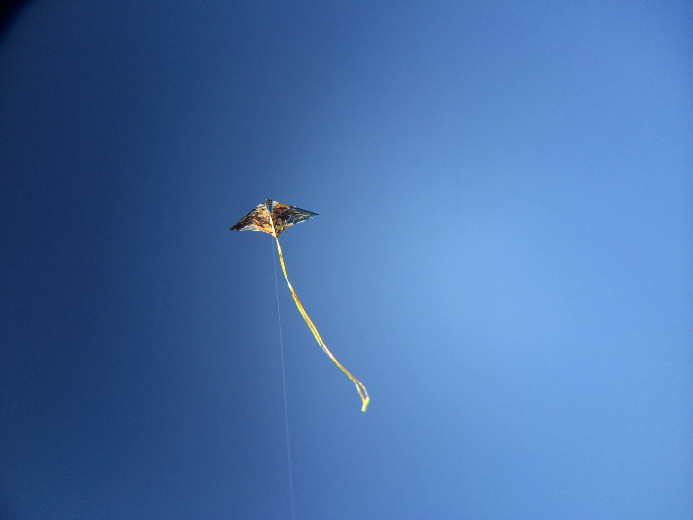 a kite flying through a blue sky in a clear day