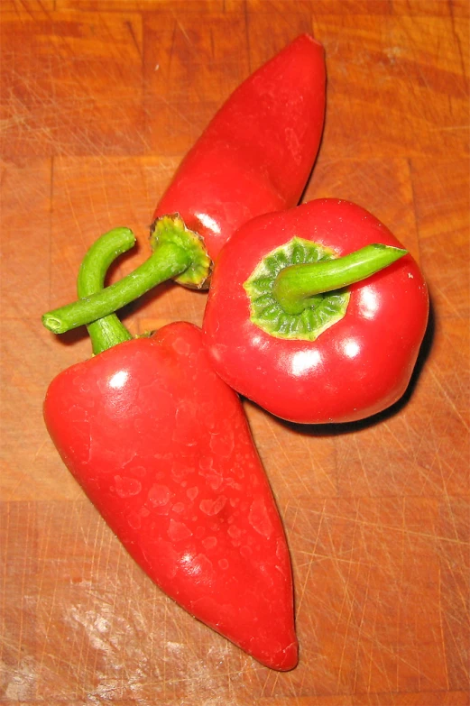 two  peppers are on a table together